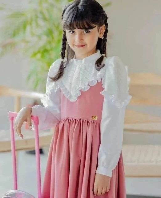 مريول بنك للأطفال فى المرحلة الابتدائية، بنت صغيرة ترتدي مريول وردي وقميص ابيض