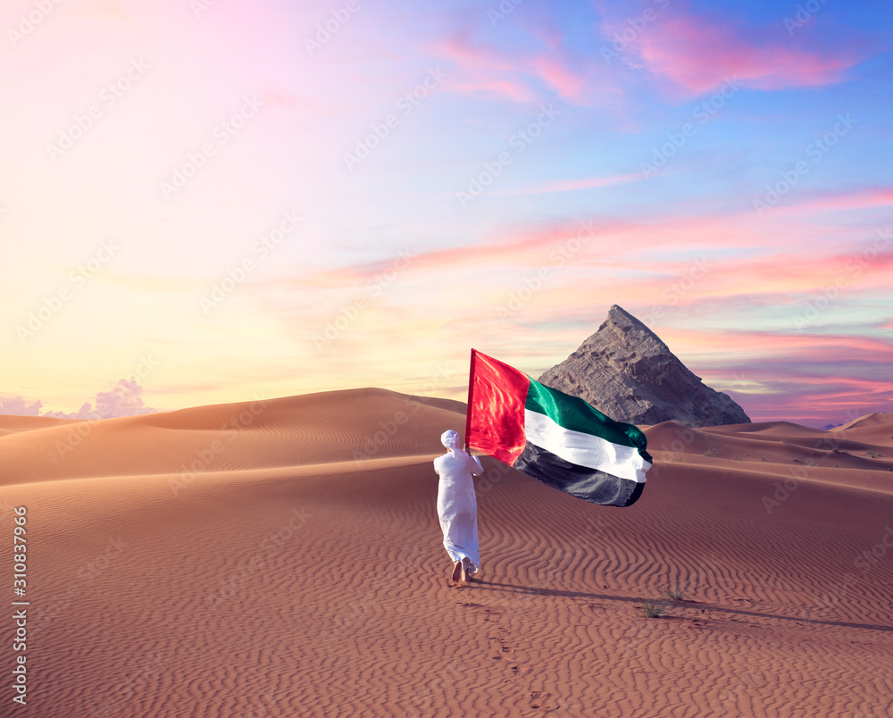 emirati man holding uae flag walking in the desert celebrate the national day spirit of the union stockpack adobe stock| وظائف بريد الامارات الادارية لجميع الجنسيات بدبي في الامارات