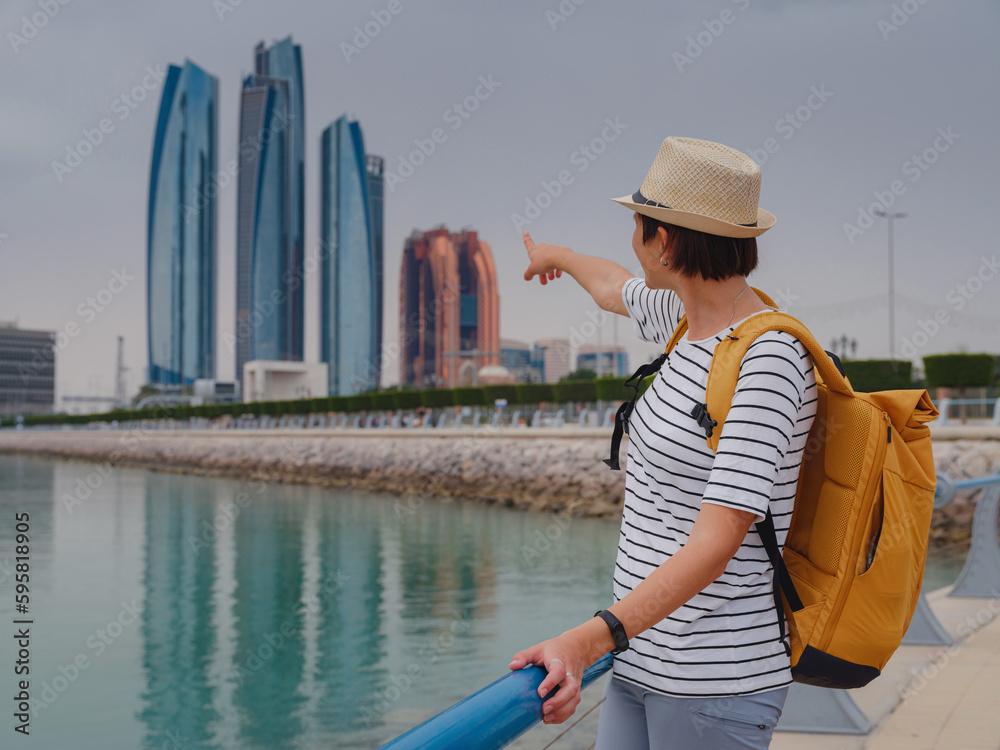 travel to the united arab emirates happy young asian female traveler with backpack and hat view to cityscape of downtown abu dhabi vacation and tourist destination concept stockpack adobe stock| وظائف شركة طلبات في قطر لجميع الجنسيات رواتب مجزية